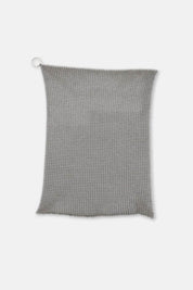 Fine stainless steel cleaning mesh laid flat against white surface