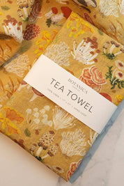 Folded Mushroom Melange Linen Tea Towel showing vibrant forest mushroom illustrations.