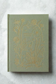 Green Herbarium Planner with gold embossed floral design on a textural light gray background