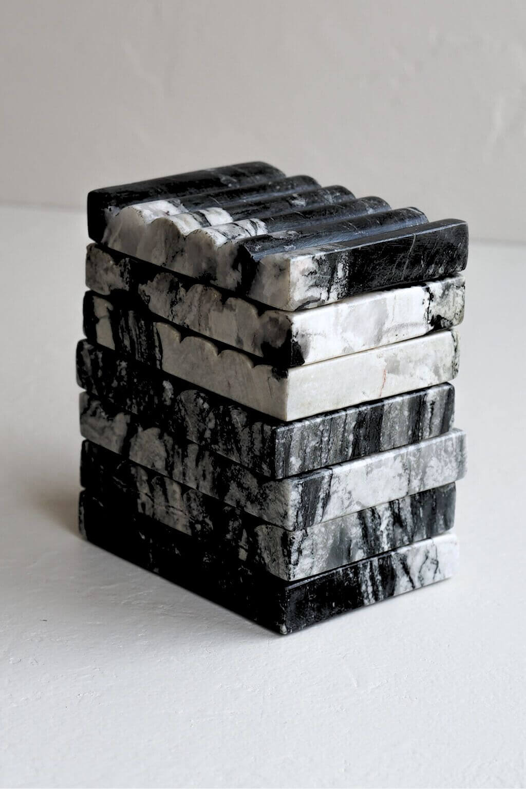 Close-up view of stacked Ridge Black Marble Soap Dishes highlighting the unique veining and striations of the stone