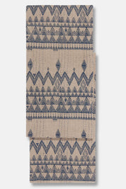 Close-up of Enigma embroidered runner showing detailed hand stitching in blue thread on tan fabric.