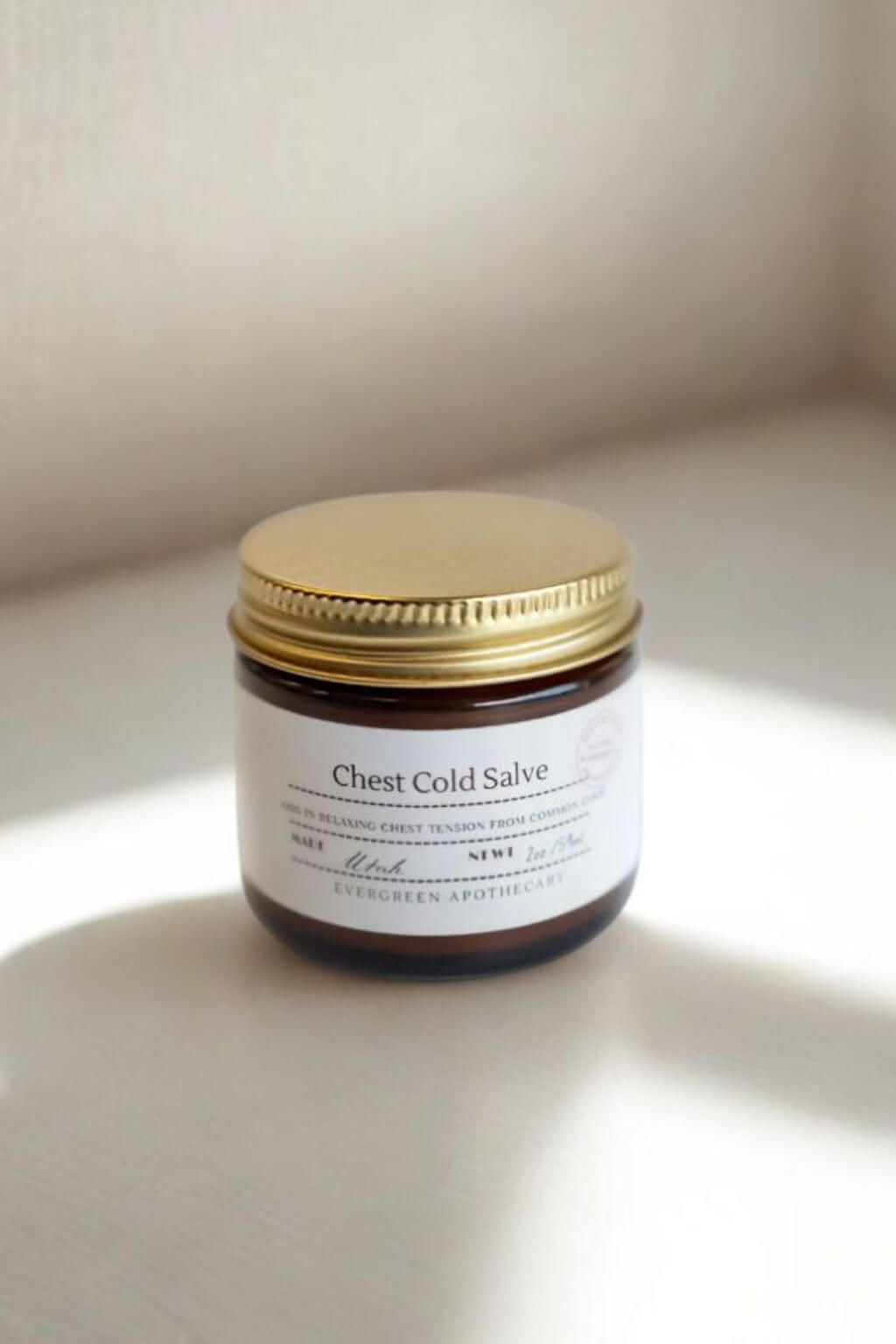 Jar of Chest Cold Salve on a light surface with a neutral background