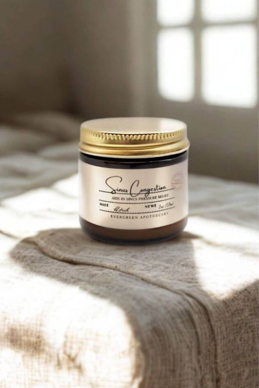 Evergreen Apothecary Sinus Congestion Salve on linen fabric with window light in background