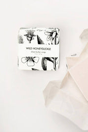 Wild Honeysuckle mini soap bar presented near botanical printed paper packaging