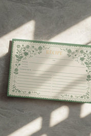 Rifle Paper Co. Artichoke Recipe Card with floral border in sunlight