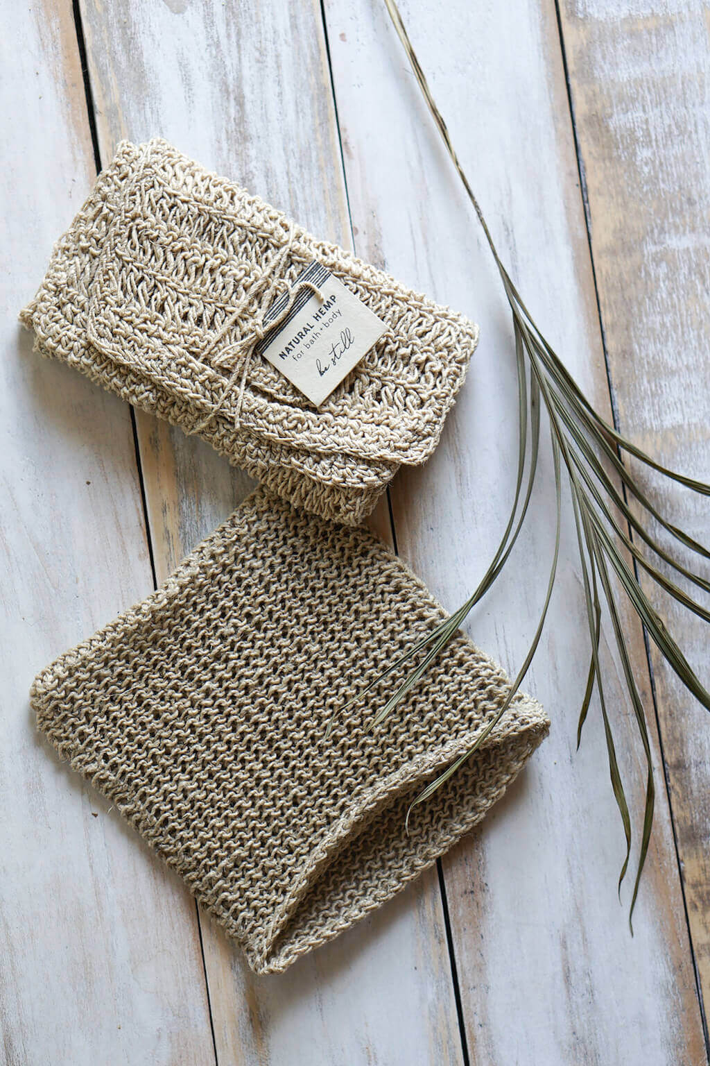 Natural crocheted hemp washcloth folded on marble surface