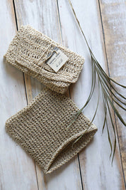 Natural crocheted hemp washcloth folded on marble surface