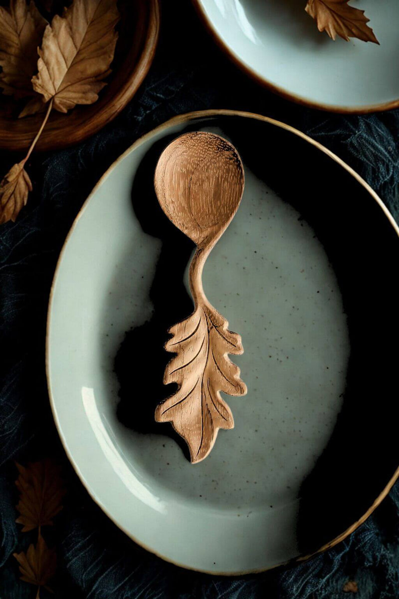 Hand-carved Oak Leaf Doussie Wood Spoon on ceramic plate