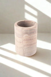 Close-up of rainbow sandstone tumbler showcasing natural layers of cream, blush, and taupe stone.