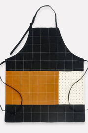 Black, orange, and white checkered apron on a white background