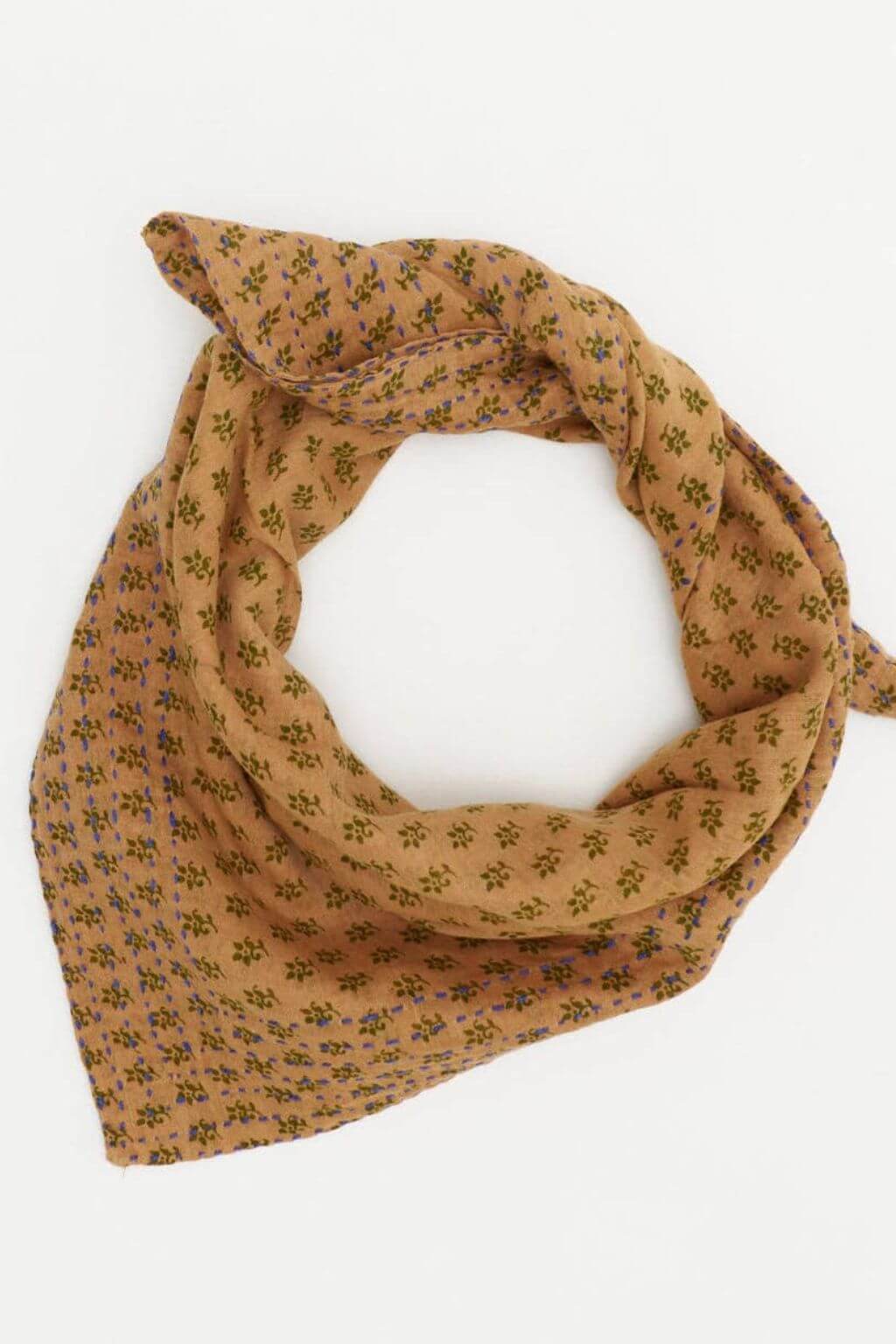 Handcrafted cotton Sylvie Bandana tied in a classic knot with woodland floral pattern on ochre.