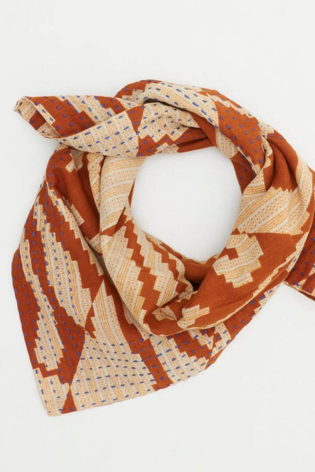 Patterned scarf in orange and beige on a white background
