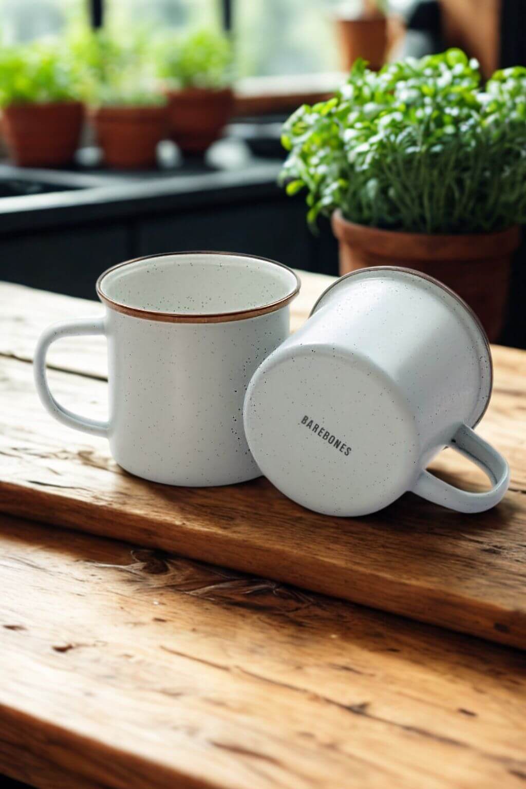 Two enamel mugs in creamy white with Barebones logo on bottom