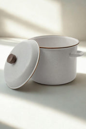 Enamel stock pot with lid slightly ajar in morning light
