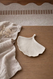 Concrete ginkgo leaf tray styled on coffee table with natural decor