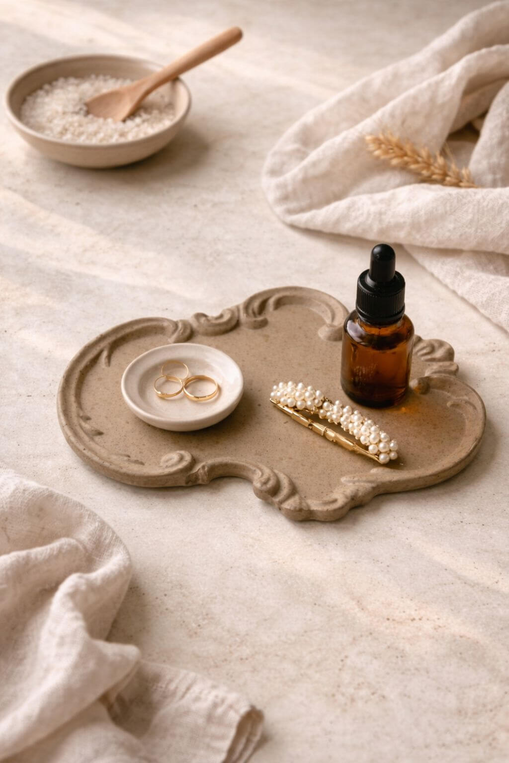 Victorian stone tray holding rings, dropper bottle, and pearl hair clip