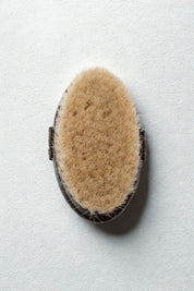 Top view of Baudelaire body brush showing engraved logo and dark wood finish