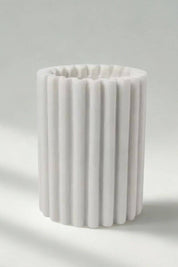 Handcrafted marble wine chiller in luminous white stone with soft vertical ridges.