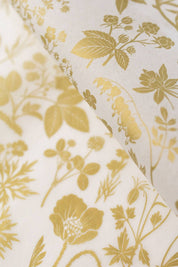 Close-up of gold foil botanical illustrations on white recycled tissue paper.