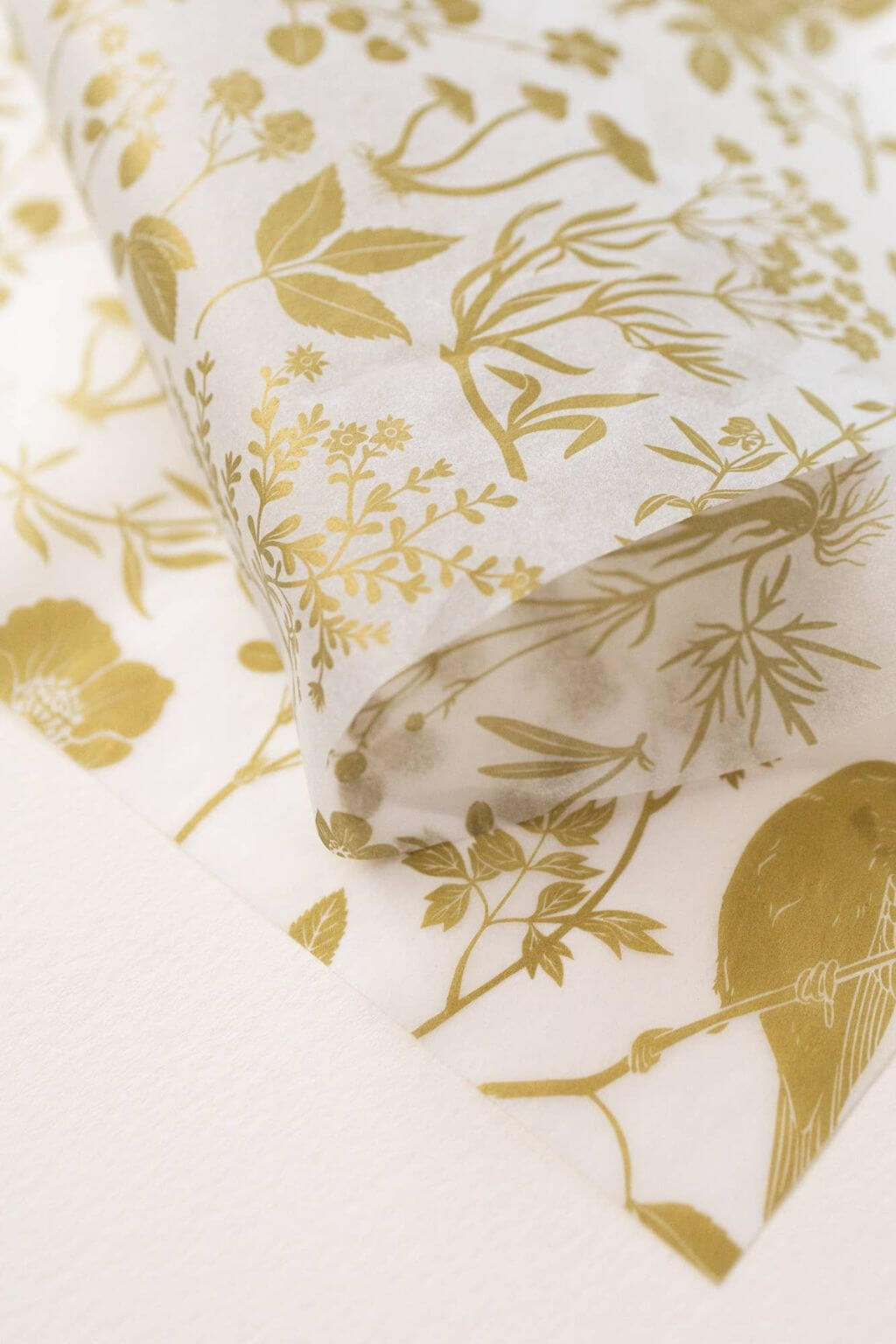 Translucent golden floral tissue paper layered and folded for eco-friendly gift wrapping.