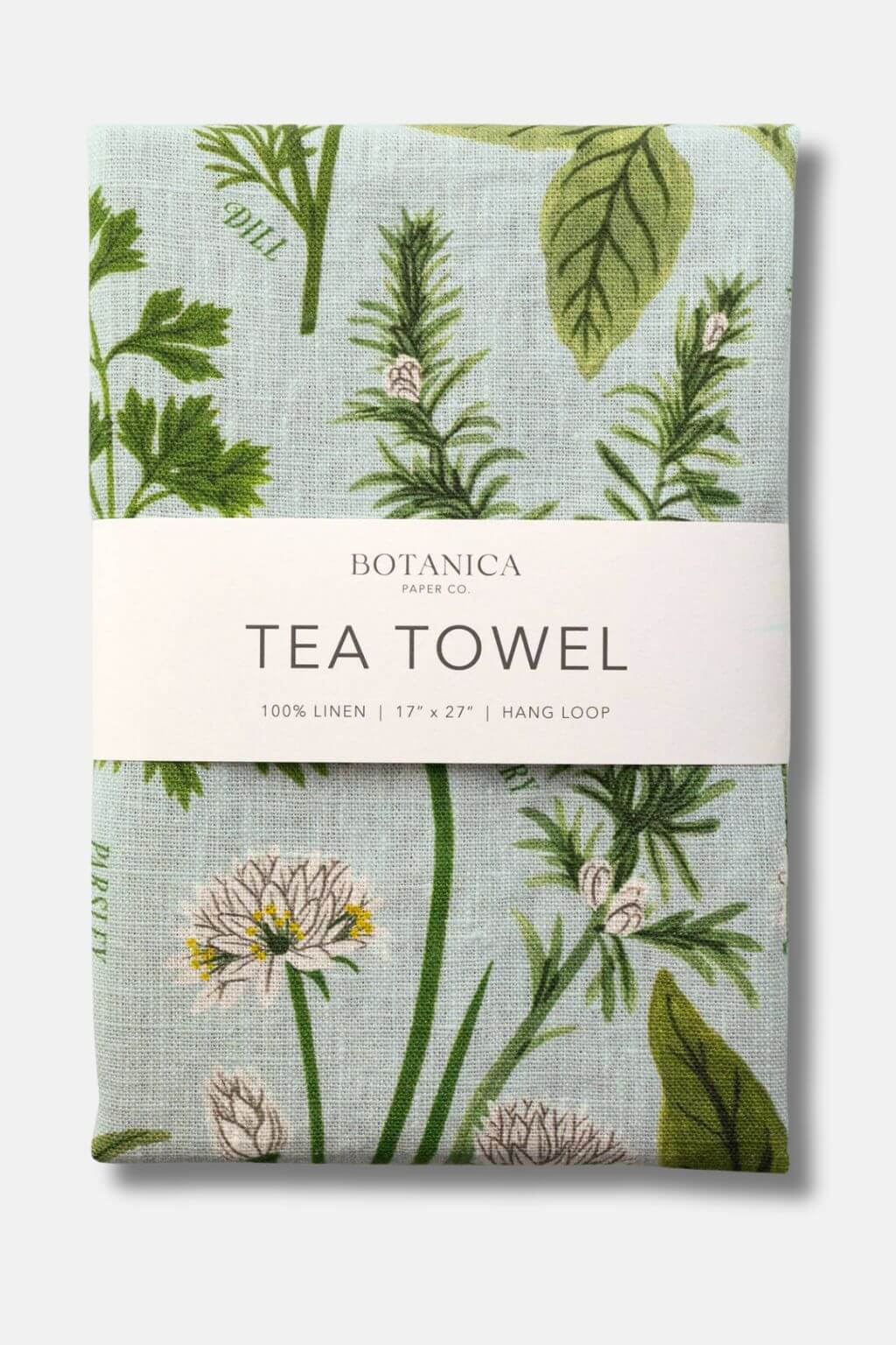 Close-up of folded Herb Garden Linen Tea Towel by Botanica Paper Co., featuring illustrated herbs like dill, parsley, and rosemary on soft blue linen fabric.