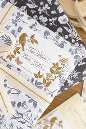 Gift wrapped in botanical paper with gold-printed Meadow label tied with ribbon.