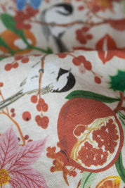 Detail of pomegranate and bird illustration printed on soft natural linen tea towel.