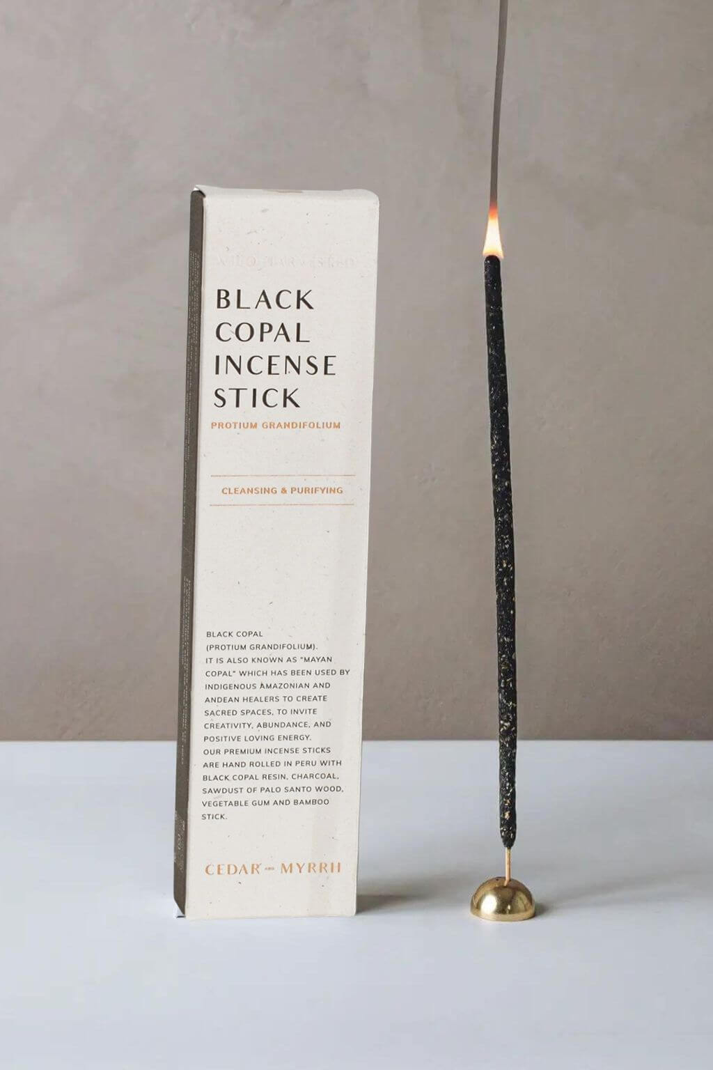 Black copal incense stick with packaging on a neutral background