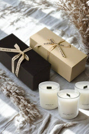 Mini Wellness Candle Gift Set with black and cream gift boxes alongside three glass votive candles labeled Spiritual, Deep Breath, and Mantra.