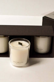 Close-up of open black gift box with Deep Breath mini candle pulled forward, flanked by Spiritual and Mantra candles.