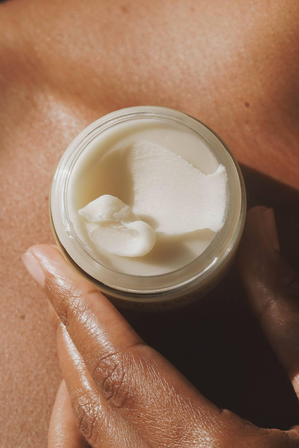 Hand scooping soft whipped deodorant from jar