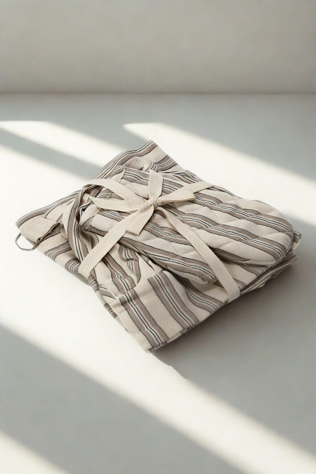 Little baker kitchen set folded and tied, natural light shadows