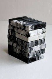 Close-up view of stacked Ridge Black Marble Soap Dishes highlighting the unique veining and striations of the stone