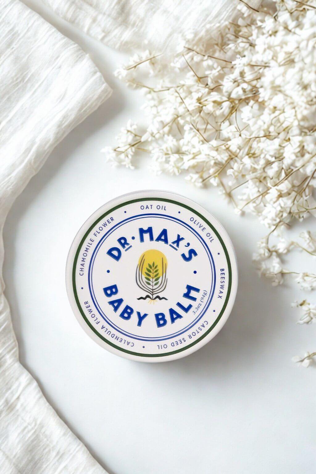 Baby balm tin styled with soft white flowers