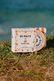 Dr. Max’s Salve-All packaging by the water outdoors
