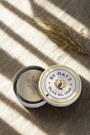 Olive oil soap tin in natural sunlight with botanical styling