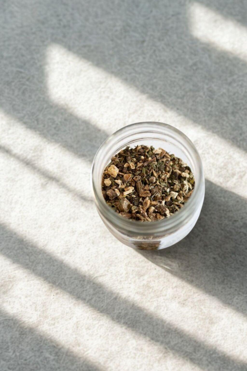 Overhead view of Anti-Inflammatea herbal tea leaves in open glass jar