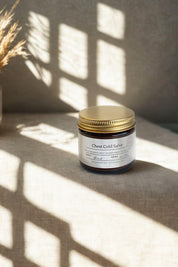 Chest Cold Salve in amber glass jar with gold lid on linen surface