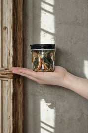 Christmas simmer pot photographed in hand beside aged wooden moulding and soft window light