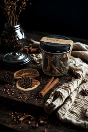 Jar of Evergreen Apothecary Christmas Simmer Pot on rustic table with dried citrus, pinecones, and cinnamon sticks