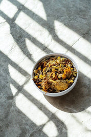 Bowl of dried Lymphatic Tea blend with chamomile, calendula, and herbs in sunlight