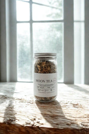Moon Tea jar from Evergreen Apothecary on wood surface with window light behind