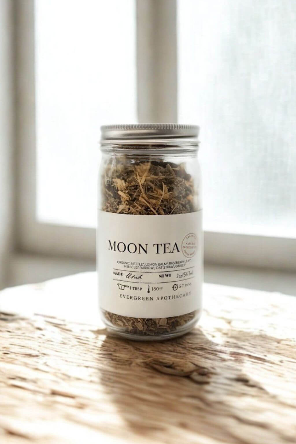 Moon Tea jar with label displayed, surrounded by warm shadows and apothecary ambiance