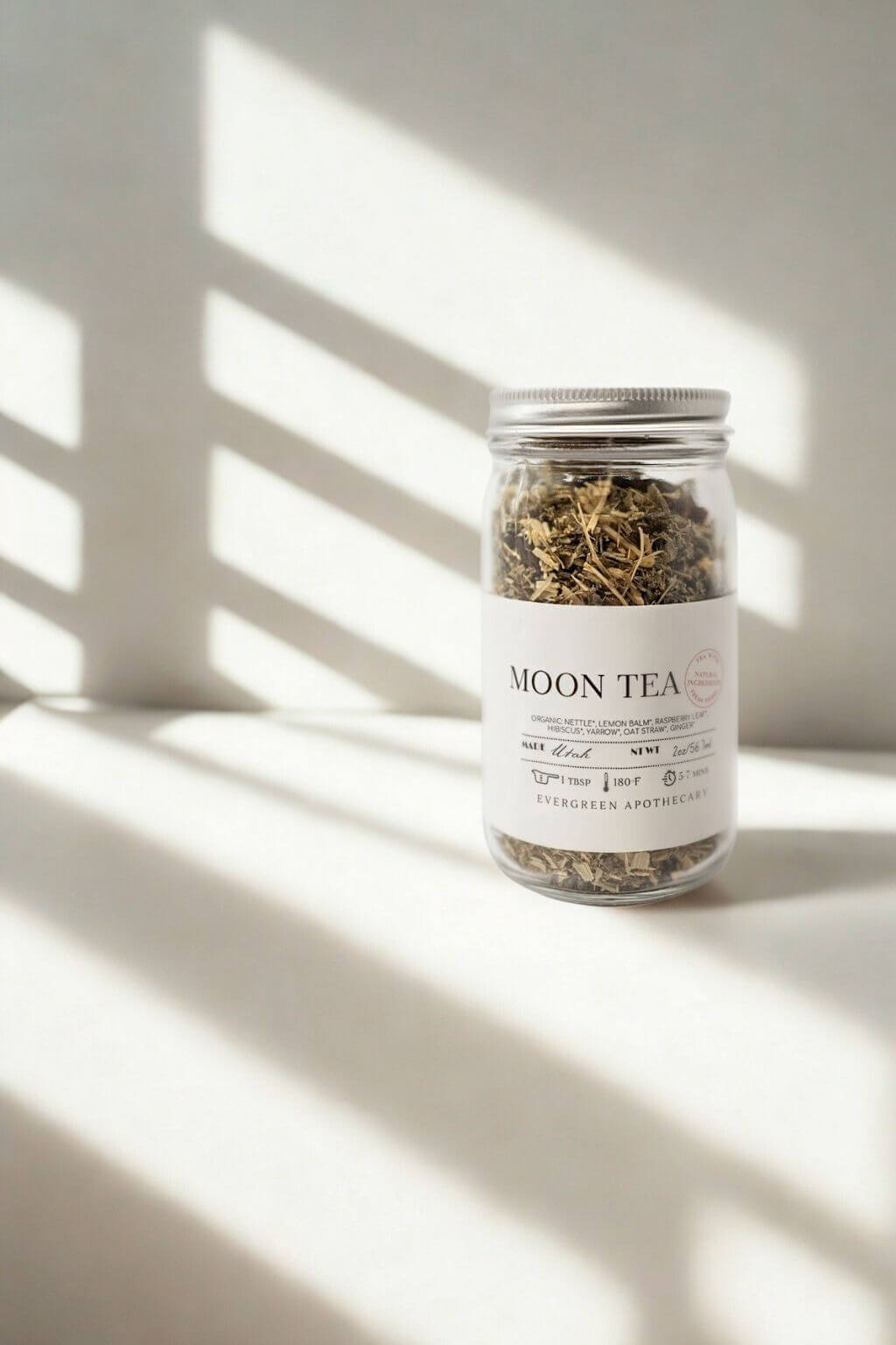 Evergreen Apothecary Moon Tea jar against pale background with shadows across the wall