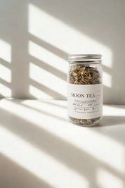 Evergreen Apothecary Moon Tea jar against pale background with shadows across the wall