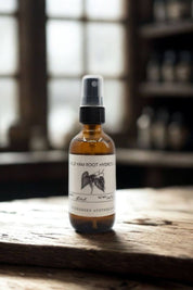 Wild Yam Root Hydrosol amber spray bottle on rustic wooden surface with blurred apothecary shelves in the background