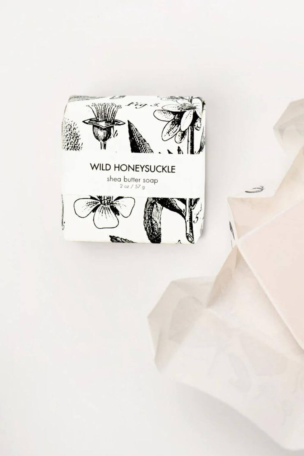 Wild Honeysuckle mini soap bar presented near botanical printed paper packaging