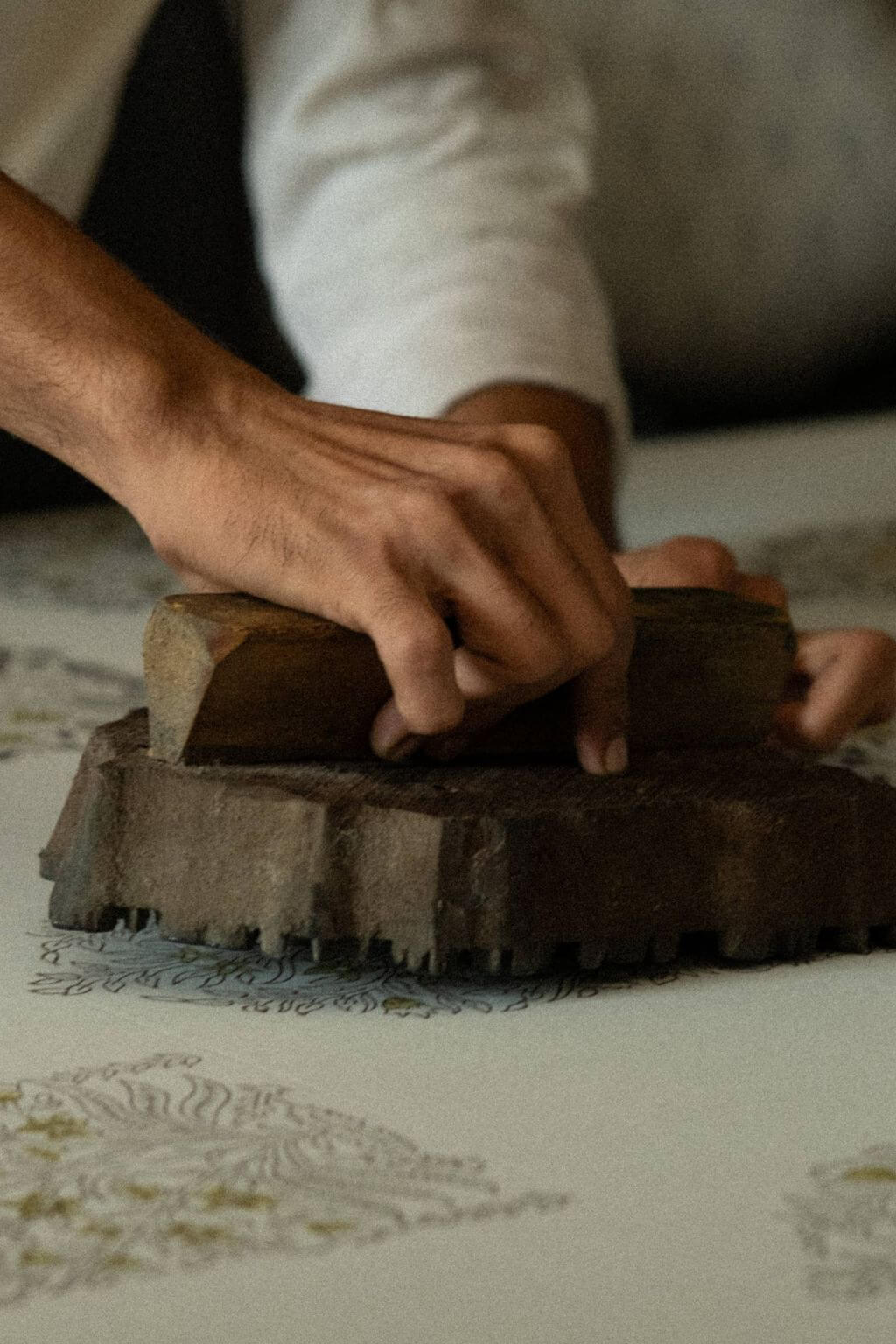 Artisan hands creating hand block printed napkins with floral pattern