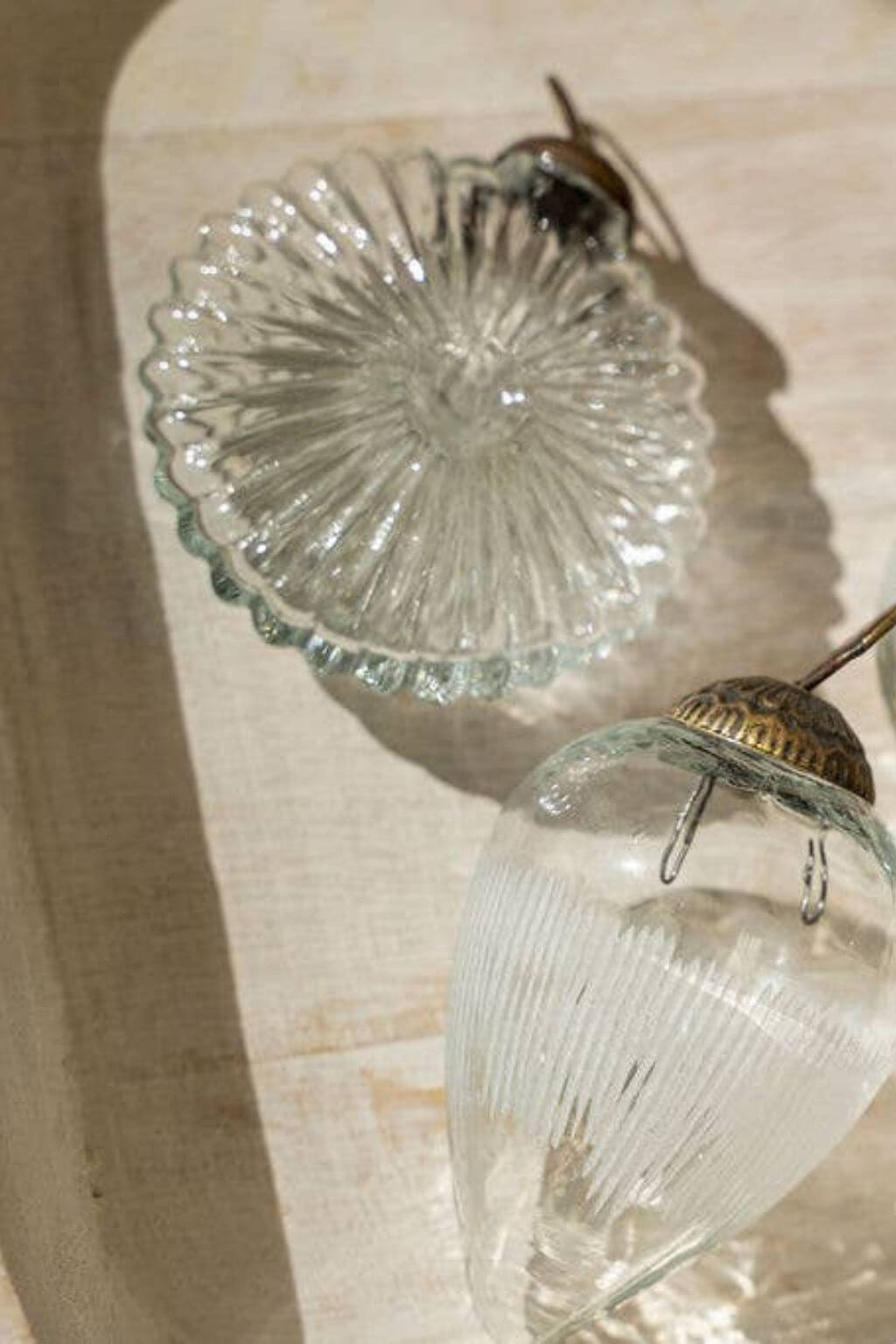 Scalloped glass ornament reflecting light in a coastal-inspired design