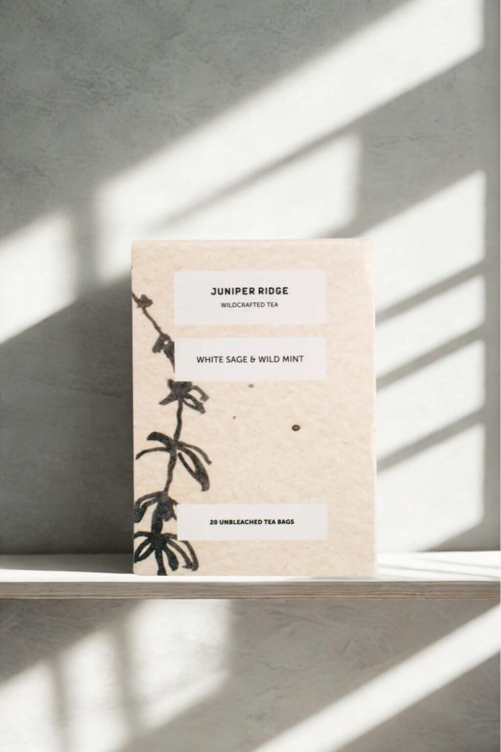 Box of Juniper Ridge White Sage and Wild Mint Tea package on a shelf with light streaming in from the window